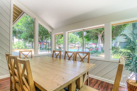 a dining room with large windows and a wooden table